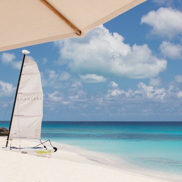 Sailboat on white sand beach with turquoise waters at Amanyara, Turks and Caicos.