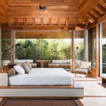 Principal bedroom with wooden ceiling, expansive windows overlooking tropical gardens at Amanyara, Turks and Caicos.