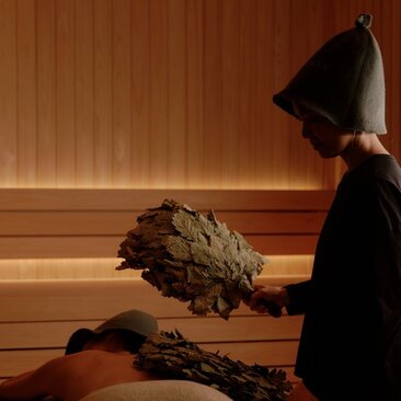Therapist applying herbal compress during wellness treatment at Aman Nai Lert Bangkok's banya spa house.
