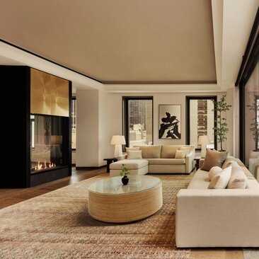 Two-bedroom home with pool at Aman New York, featuring a spacious living area with cream furnishings and round central table.