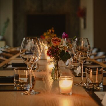 Sala privata per cene presso Aman New York con tavolo illuminato da candele e composizioni floreali.