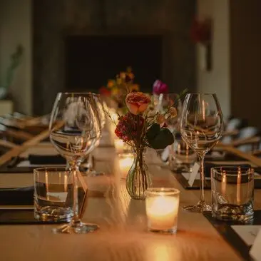 Salle à manger privée élégante à l'Aman New York avec table dressée, fleurs et bougies.