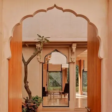Garden Haveli Suite entrance at Amanbagh, India, with carved archway and potted plant.