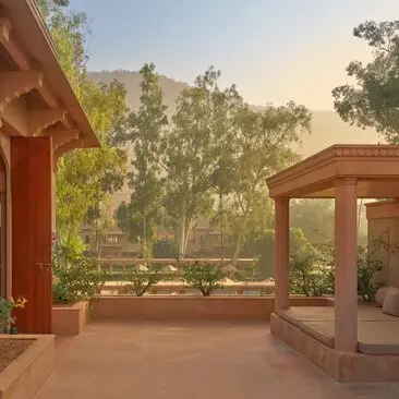 Terrace of a Haveli Suite at Amanbagh with views across gardens at dawn, India.