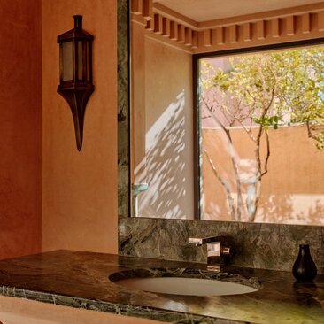 Deluxe Pavilion bathroom with arched window overlooking Moroccan landscape at Amanjena resort.