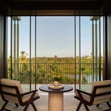 Elevated casita at Amanvari with two chairs facing expansive desert views through floor-to-ceiling windows.