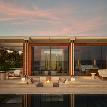 Estuary Casita terrace at dusk with wooden loungers and lanterns overlooking the water at Amanvari, Mexico.