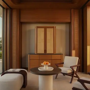 Estuary Casita lounge with warm wooden interiors, seating area and round table at Amanvari resort, Mexico.