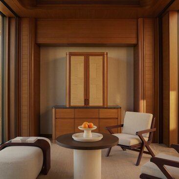 Estuary Casita interior at Amanvari with wooden furnishings, round table, and chair overlooking Mexico's waterfront landscape.