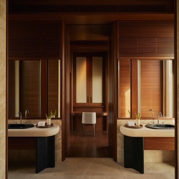 Bathroom at Amanvari with dual vanities and warm wooden cabinetry.