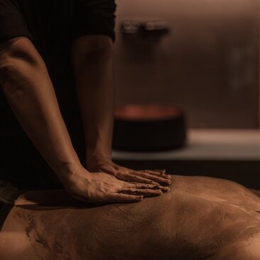 Therapist's hands performing a body scrub treatment at Amanyangyun spa in China.