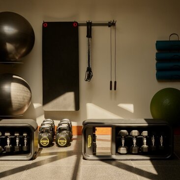 Spa and wellness gym at Amanyara resort, with exercise balls, weights, and wellness products arranged on shelving.