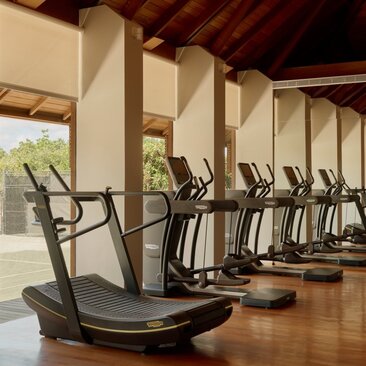 Salle de sport avec équipements de fitness alignés sous un auvent ouvert à Amanyara, resort aux Îles Turques-et-Caïques.