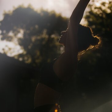 Silhouette of a therapist's hands during a wellness treatment at Amanyara resort, backlit by golden light.