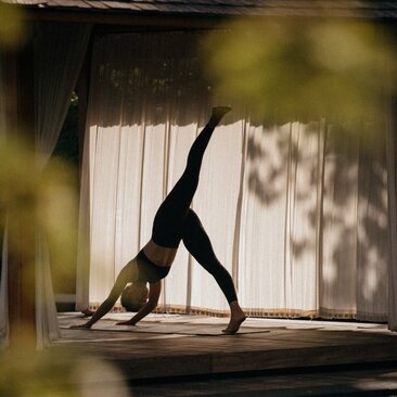 Yoga instructor in downward dog pose at Amanyara resort spa and wellness centre, Turks and Caicos.