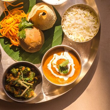 Plateau de plats indiens variés à Amankila, incluant dhal épicé, riz et légumes verts.