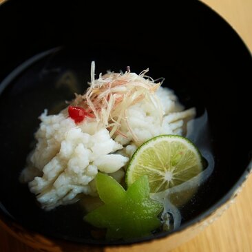 安缦黛宁度假村的汤碗，清汤中浮有白色面条、新鲜蔬菜和青柠片。