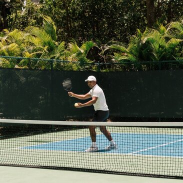 Joueur de pickleball en action sur un court à Amanera, République dominicaine.