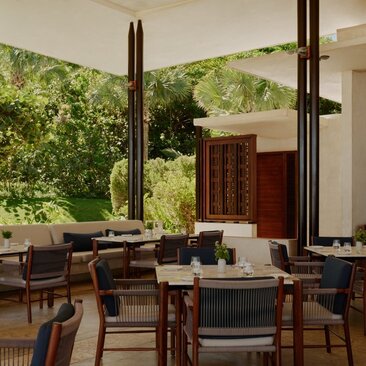 Club de plage d'Amanera en République dominicaine, avec salle à manger ouverte sur jardin verdoyant.