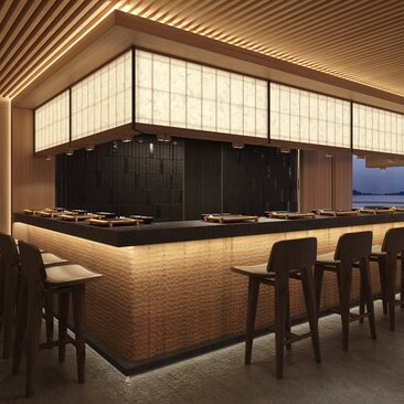 Open-plan kitchen with illuminated counter seating at Aman at Sea.