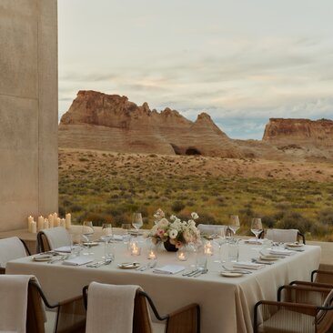 Desert lounge with private dining table overlooking red rock formations at Amangiri, USA.