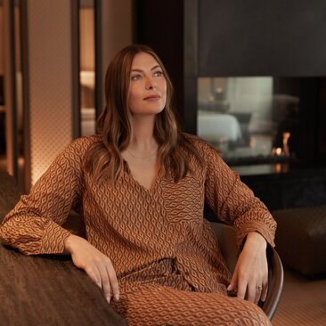 Maria Sharapova seated in a warm-toned interior at Aman New York, wearing a textured knit sweater.