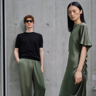 Kim Jones Parley collection at Aman New York hotel; two models wearing black and olive-green casual apparel against concrete backdrop.