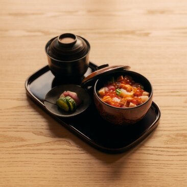 Akari dining experience at Aman New York, featuring two bowls of Japanese cuisine on a black tray.