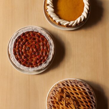 Thanksgiving pies at Aman New York hotel, including cranberry and pumpkin varieties with woven crusts.