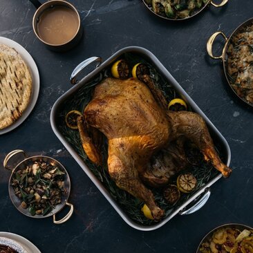 Roasted turkey surrounded by traditional Thanksgiving side dishes at Aman New York hotel.