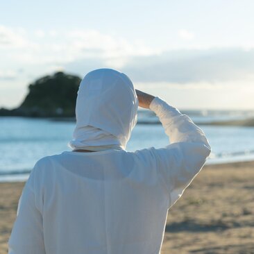 Ama diver in white clothing gazing towards the sea at Amanemu resort, Japan.
