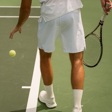 Joueur de tennis en tenue blanche sur le court à Aman New York.