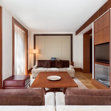 Queen Marija Suite living room at Aman Sveti Stefan, featuring warm wood tones and contemporary furnishings.