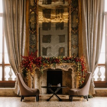 Tiepolo Room fireplace dressed with festive garland and Christmas decorations at Aman Venice.