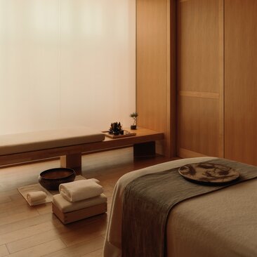 Camera per trattamenti spa con futon e tavolo basso in legno, Aman Tokyo.