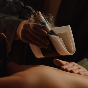 Moxibustion treatment being applied to a guest's back at Amanemu spa in Japan.