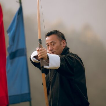 Archer drawing bowstring at Amankora's in-house archery activity in Punakha.