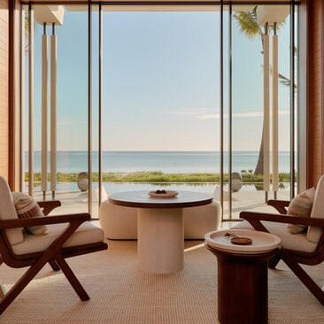 Beachfront casita living area at Amanvari with sea view through floor-to-ceiling windows and contemporary furnishings.