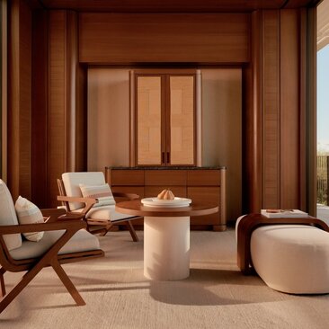 Living area of a Casita at Amanvari, Mexico, featuring warm wooden panelling, a neutral pouf, and modern furnishings.