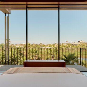 Casita bedroom with expansive windows overlooking Amanvari's desert landscape and private soaking tub.