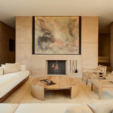Sala principale di una villa con sei camere da letto ad Amangiri resort, con camino e arredi in legno naturale.