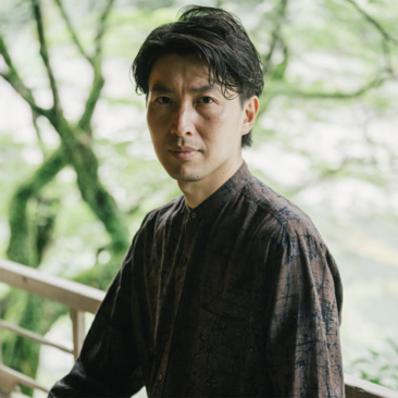 Satoshi Nemoto, a staff member at Aman New York, photographed outdoors amongst greenery.