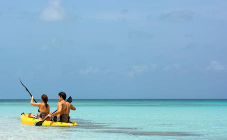 家庭在安缦涯澜度假村的浅绿色海水中享受水上活动。