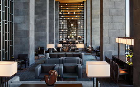 Aman Tokyo's lounge features a sunken seating area with fireplace and floor-to-ceiling windows.