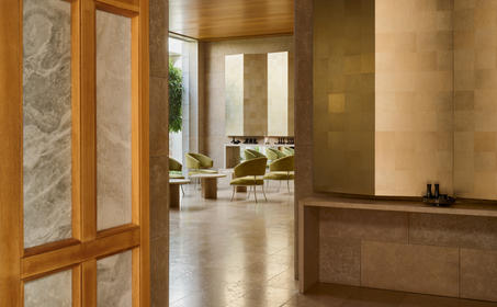 Spa interior lounge at Amanzoe with warm wooden tones and serene neutral palette.