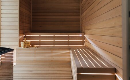 Wooden sauna interior at Amanzoe with tiered benches and warm lighting.