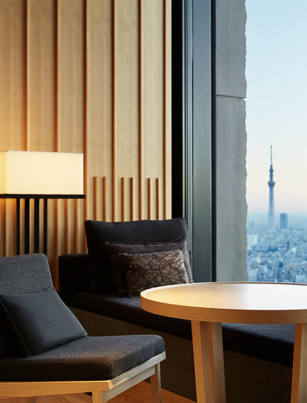 Galeria con asiento junto a ventana y vistas a Tokio en Aman Tokyo.