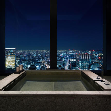 Soaking tub overlooking Tokyo's illuminated cityscape at night, Aman Tokyo.