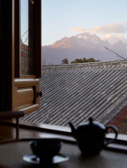 大研安缦度假村的瓦顶景观，远处可见雪山，窗边置有陶罐。