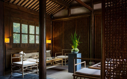 Serene wellness space at Amanfayun with wooden architecture, potted plant, and traditional furnishings.